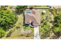 Sprawling home boasts an open layout, screened pool, long driveway and mature landscaping at 2300 Carpenter Ln, North Port, FL 34286