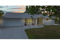 Charming single-story home featuring an attached two-car garage and well-maintained landscaping at 2442 Rio De Janeiro Ave, Punta Gorda, FL 33983