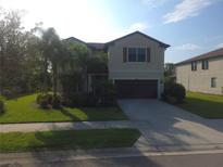 Charming two-story home with lush landscaping, well-maintained lawn, and a spacious driveway leading to a two-car garage at 2739 Sherman Oak Dr, North Port, FL 34289