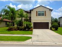 Inviting two-story home with a well-manicured lawn and a two-car garage, perfect for Gathering living at 2739 Sherman Oak Dr, North Port, FL 34289
