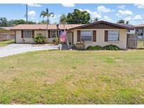 Charming single-story home featuring a well-maintained lawn, palm trees, and an American flag at 315 Holly Rd, Venice, FL 34293
