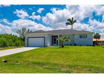 Well-maintained single-story home with green lawn, garage, and attractive landscaping details at 3302 Palm Dr, Punta Gorda, FL 33950