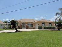 Beautiful single-story home featuring a well-manicured lawn, tiled roof, and an inviting entrance at 3398 Tripoli Blvd, Punta Gorda, FL 33950