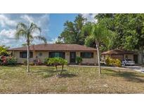 Charming single-story home with a well-maintained front yard, mature trees, and a detached garage at 4071 Dekle Ave, North Port, FL 34286