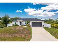 Charming single-story home showcasing a well-manicured lawn, two-car garage and a welcoming front entrance at 5532 Veracruz Ter, Port Charlotte, FL 33981