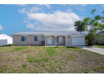 Charming single-story home featuring a well-maintained lawn and attached garage at 6850 S Biscayne Dr, North Port, FL 34287