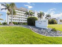Beautiful white building Palacio Del Sol 1500 with tropical landscaping and palm trees at 1500 Park Beach Cir # 5E, Punta Gorda, FL 33950