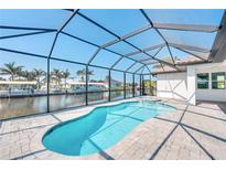 Screened-in pool and spa overlooking the canal, offering a private oasis at 15698 Meacham Cir, Port Charlotte, FL 33981