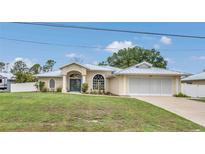 Beautiful single-story home with a well-manicured lawn, charming curb appeal, and a two-car garage at 1761 Okolona St, North Port, FL 34287