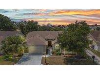 Charming single-Gathering home with a well-maintained lawn, mature trees, and a two-car garage at sunset at 1876 Birmingham Blvd, Punta Gorda, FL 33980