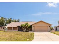 Single-story home with a two-car garage, landscaped yard, and mature trees at 238 Mark Twain Ln, Rotonda West, FL 33947