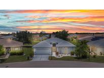 Charming single-story home boasts a well-manicured lawn and a picturesque sunset backdrop at 24312 Westgate Blvd, Port Charlotte, FL 33980
