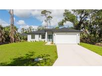 Beautiful one-story home featuring a well-manicured front yard and a two-car garage at 355 Milton St, Port Charlotte, FL 33954