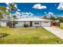 Charming single story home with metal roof, green lawn, and mature landscaping at 416 Allen St, Punta Gorda, FL 33950