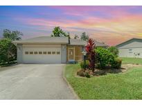 Charming single-story home with a well-manicured lawn, screened entrance, and two-car garage at 541 Wekiva River Ct # 94, Englewood, FL 34223