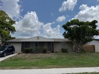 Charming one-story home featuring a screened entrance, attached garage, and a well-manicured front yard at 8158 Trionfo Ave, North Port, FL 34287