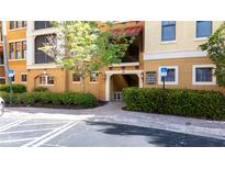 Welcoming entrance with manicured landscaping to a beautiful yellow condo building with stairs and balconies at 99 Vivante Blvd # 310, Punta Gorda, FL 33950