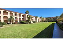Sprawling condominium complex featuring well manicured lawn, lush landscaping and covered balconies at 1 Colony Point Dr # B20, Punta Gorda, FL 33950