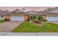 Charming single-story villa boasts an attached garage, manicured landscaping, and a welcoming brick driveway at 2028 Lynx Run, North Port, FL 34288
