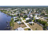 Aerial view of a waterfront home with canal access and lush greenery in a residential neighborhood at 2028 River Basin Ter, Punta Gorda, FL 33982