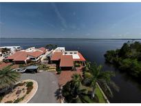 Waterfront home features a charming red tile roof, lush landscaping, and brick-paved drive, with stunning views of the bay at 25188 Marion Ave # 1, Punta Gorda, FL 33950
