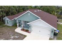 Charming single-Gathering home featuring a well-maintained yard, covered entryway, and attached two-car garage at 2858 Parlay Ln, North Port, FL 34286