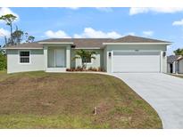 Charming single-story home featuring a two-car garage and well-manicured front yard at 5353 Kaspar St, Port Charlotte, FL 33981