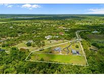 Beautiful aerial view of a sprawling home with a pool and guesthouse surrounded by lush greenery and defined property lines at 5600 Blackjack S Ct, Punta Gorda, FL 33982
