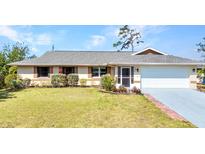 Charming single-story home featuring a well-maintained lawn and an attached two-car garage at 566 Reading Nw St, Port Charlotte, FL 33952