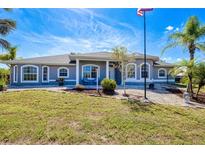 Charming single-story home with a manicured lawn, rock landscaping and a welcoming front entrance at 7274 Alan Blvd, Punta Gorda, FL 33982