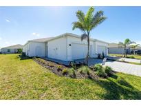 New construction home featuring a landscaped yard, white exterior, and attached two-car garage at 8700 Seasalt Loop, Englewood, FL 34224