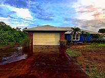 Charming single-story home features a large garage and colorful exterior paint at 10229 Gulfstream Blvd, Englewood, FL 34224