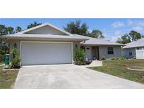 Charming single-Gathering home featuring a two-car garage, metal roof, and well-manicured front lawn at 11422 2Nd Ave, Punta Gorda, FL 33955