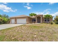 Charming single-story home with well-maintained landscaping and a three-car garage at 15104 Aldama Cir, Port Charlotte, FL 33981