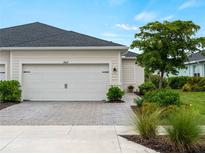 Charming home featuring a two-car garage with brick paver driveway and beautifully landscaped front yard at 17857 Woodland Ct, Punta Gorda, FL 33982