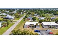Aerial view of a home in a quiet neighborhood with lush greenery and a well-maintained lawn at 232 W Henry St, Punta Gorda, FL 33950
