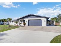 Well-maintained single-story home with a two-car garage and a beautiful, spacious concrete driveway at 711 Forest Hill Nw Ln, Port Charlotte, FL 33948