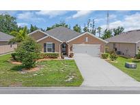 Charming single-story home featuring a well-manicured lawn, covered entry, and attached two-car garage at 7652 Mikasa Dr, Punta Gorda, FL 33950