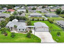 Inviting single-Gathering home with attached two-car garage, luscious lawn and tropical landscaping at 23493 Taber Ave, Port Charlotte, FL 33954