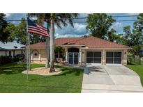 Beautiful single-story home with a well-manicured lawn, tile roof, and American flag at 2387 Nuremberg Blvd, Punta Gorda, FL 33983
