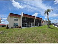 Exterior view of condo building with screened-in lanais and well-maintained lawn at 311 Garvin St # 405B, Punta Gorda, FL 33950