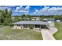 Charming single-story home with attached carport and ample yard space under a blue sky at 3171 Highlands Rd, Punta Gorda, FL 33983