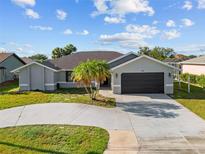 Charming single-story home featuring a circular driveway and mature palm trees in a well-maintained lawn at 411 Scarlet Sage, Punta Gorda, FL 33955