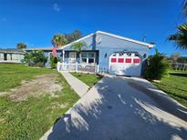 Charming single-story home boasts a well-maintained lawn, bright blue siding, and a white picket fence for added curb appeal at 4583 S Salford Blvd, North Port, FL 34287