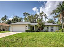 Well-maintained single-story home with a spacious lawn and attached two-car garage in a landscaped neighborhood at 4609 Jaslo Ave, North Port, FL 34286
