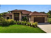 Stunning single-story home with manicured lawn and elegant landscaping, complemented by a two-car garage at 5451 Prime Ter, North Port, FL 34286