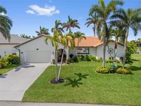 Charming single-story home with well-manicured lawn and mature palm trees at 632 Brindisi Ct, Punta Gorda, FL 33950