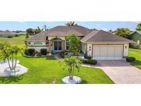 Well-maintained home boasts manicured lawn, decorative landscaping, and a brick driveway leading to an attached two-car garage at 1499 Nuremberg Blvd, Punta Gorda, FL 33983