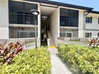 Exterior view of a two-story condo building with well-maintained landscaping and clearly marked unit numbers at 1515 Forrest Nelson Blvd # D102, Port Charlotte, FL 33952
