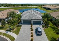 Beautiful home with a well-manicured lawn, paver driveway, tile roof and pond view at 15974 Clear Skies Pl, Bradenton, FL 34211